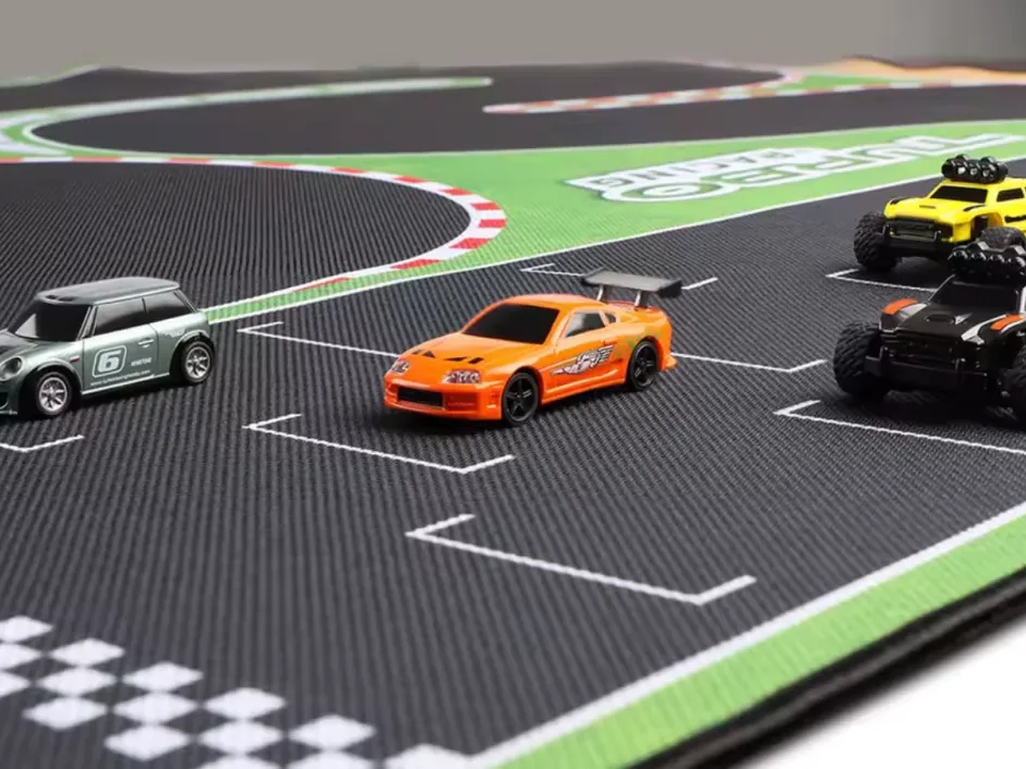 Grille de départ sur tapis de course RC 1/76 : une MINI, un coupé orange et deux buggys alignés